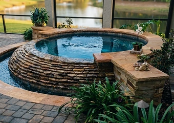 A round stacked-stone spa surrounded by planting