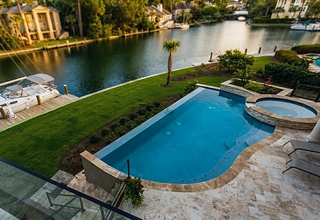 A pool and lawn seen from above, showing access and drainage across the lot