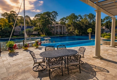 A finished terrace, dining table and pergola beside a completed pool