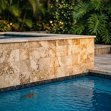 A pale stone wall above the clear water of a fiberglass pool